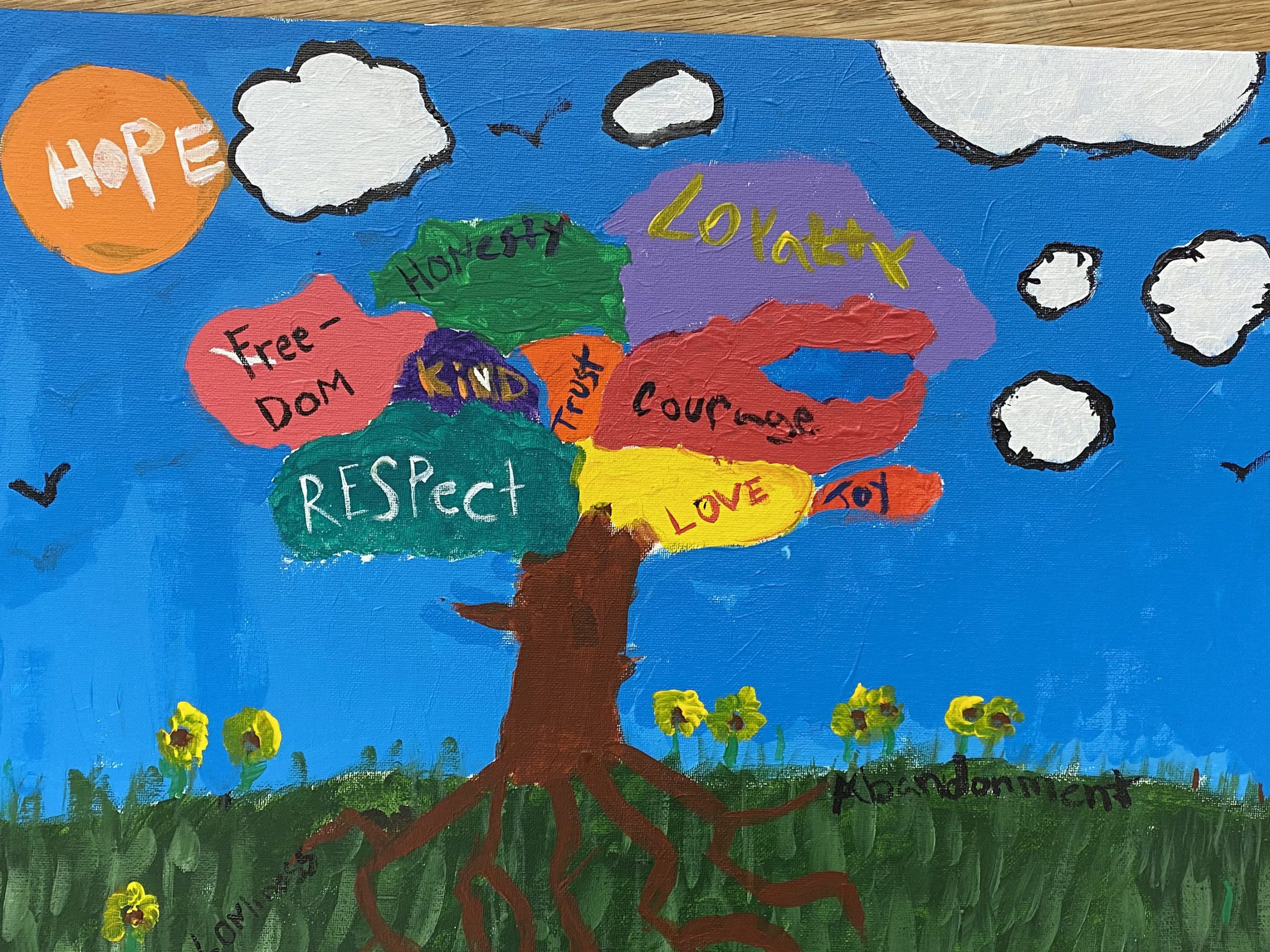 Painting by the youth of a tree with large works such as: Hope, Respect, Love. 