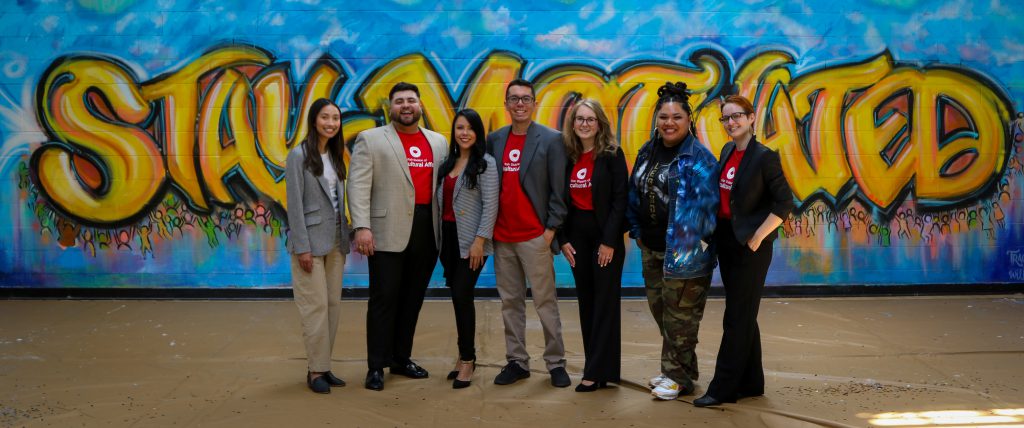 Full picture of the team who attended the JJYS ceremony. The mural "Stay Motivated" is painted in big yellow letters in the background. 